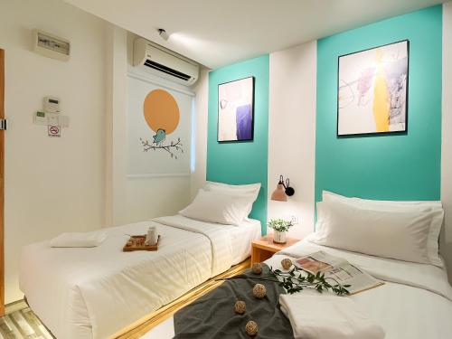 two beds in a room with blue and white walls at Apple 1 Hotel Gurney in George Town