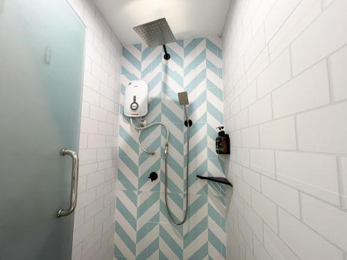 a bathroom with a shower with blue and white tiles at Apple 1 Hotel Gurney in George Town