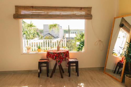 a table with a candle on it in a room with a window at Entire Second Floor - Nguyên Tầng 2 - Nhà Mơ Homestay Bến Tre in Ben Tre
