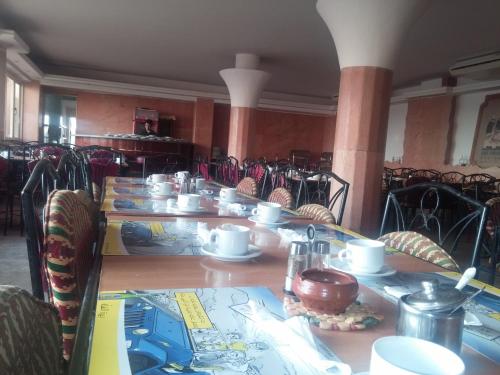 a row of tables with plates and cups on them at Ciao Hotel in Nuweiba