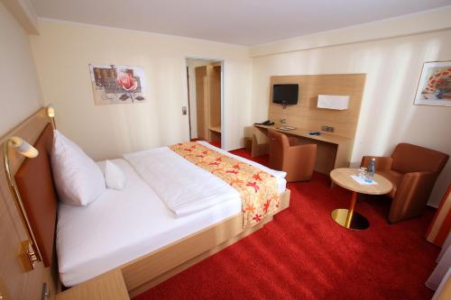 a hotel room with a bed and a desk at Hotel Schwanen in Kehl am Rhein