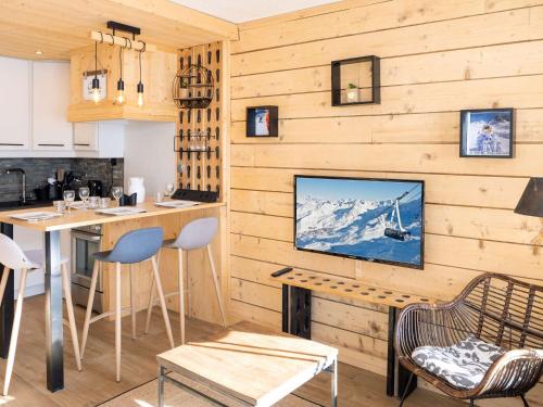 une cuisine avec une télévision sur un mur en bois dans l'établissement Bel appartement rénové 4 pers, cuisine équipée, proche commerces - FR-1-637-56, à Val Thorens