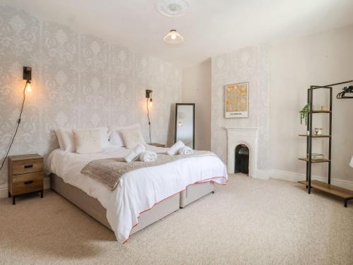 a bedroom with a large bed and a fireplace at Beautiful 4 Bed Beach House - Pool table & Parking in Pakefield