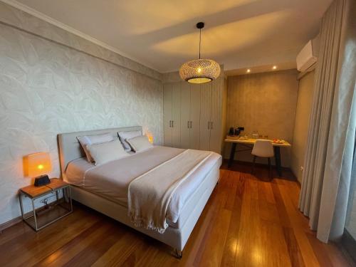 a bedroom with a large bed and a table at Casa do Mundo Madeira in Gaula