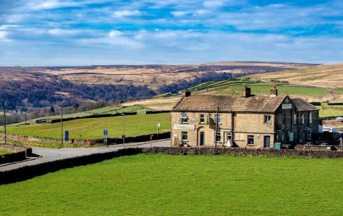 an old house in the middle of a green field at The Crossroads Inn in Halifax