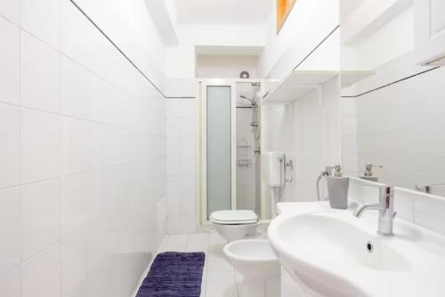 a white bathroom with a sink and a toilet at Casa Paradiso sul Mare delle Aci in Aci Catena