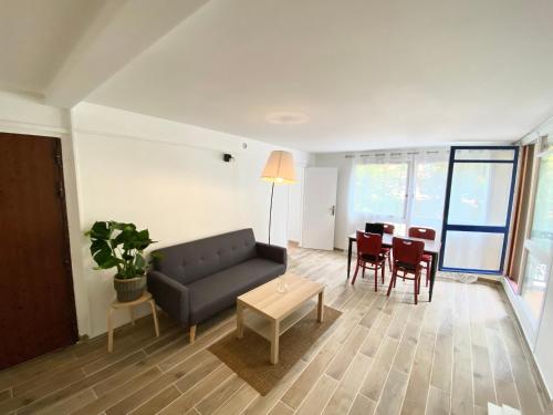 un salon avec un canapé et une table dans l'établissement Appart tout confort pour famille RER A 2min, à Cergy