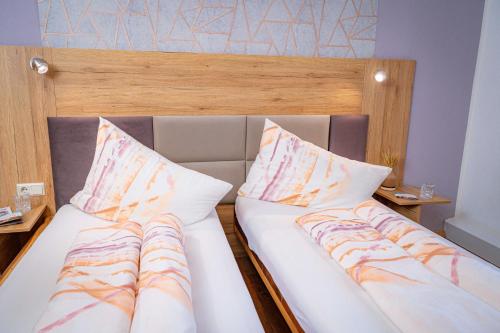 two beds with pillows in a room at Pension Sandhof in Knittelfeld