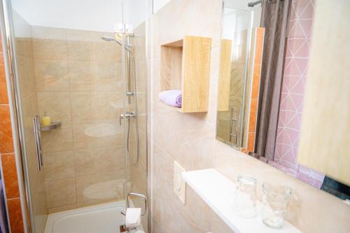 a bathroom with a shower and a sink and a mirror at Pension Sandhof in Knittelfeld