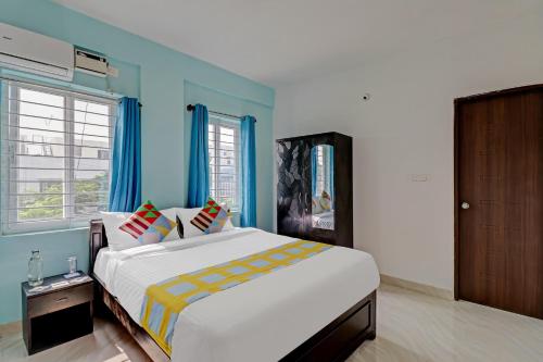 1 dormitorio con 1 cama grande y paredes azules en OYO Nr Royal en Bangalore