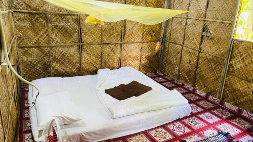 a small room with a white bed in a tiled room at NLCO Homestay in Siem Reap
