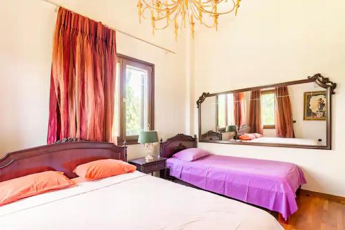 a bedroom with two beds and a large mirror at Villa OINOI with Pool for Luxury Vacation and Events in Marathón