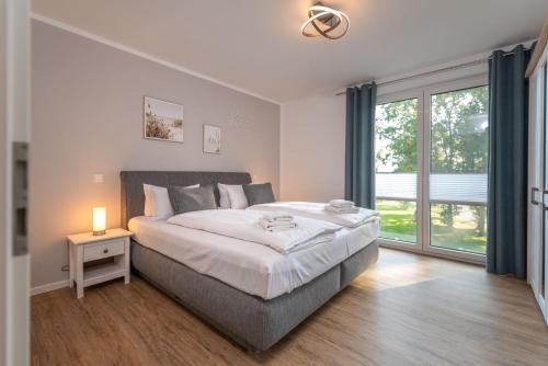 ein Schlafzimmer mit einem großen Bett und einem großen Fenster in der Unterkunft Ferienwohnung "Haffsonne" - Whg 7 10 in Zirchow
