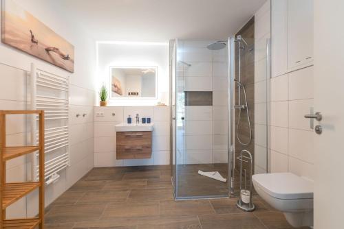 uma casa de banho com um chuveiro, um WC e um lavatório. em Ferienwohnung "Haffsonne" - Whg 7 10 em Zirchow