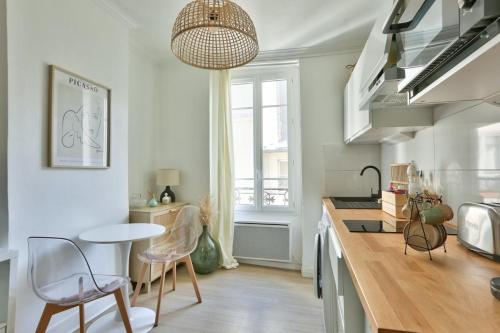 een keuken met een tafel en stoelen in een kamer bij Pretty 24 m near Batignolles in Parijs