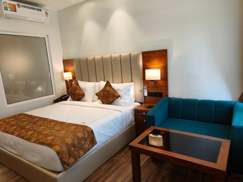 a hotel room with a bed and a blue couch at Hotel Guru Surbhi in Pāonta Sāhib