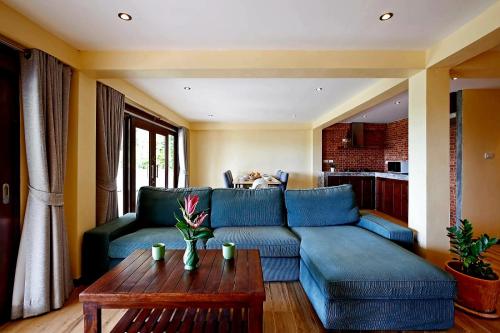 uma sala de estar com um sofá azul e uma mesa em Dream view "The Balcony & Terrace Garden" em Ko Phangan