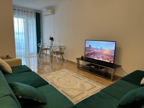 uma sala de estar com um sofá e uma televisão de ecrã plano em Beach front Superior Apartment em Durrës
