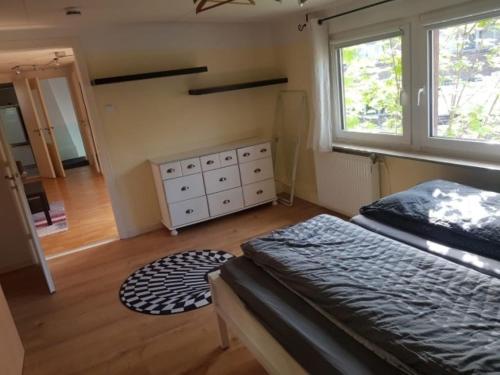een slaapkamer met een bed, een dressoir en ramen bij Haus Mara in Emden