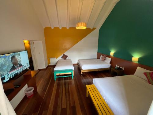 a room with two beds and a flat screen tv at Usgar San Pedro Boutique in Cusco