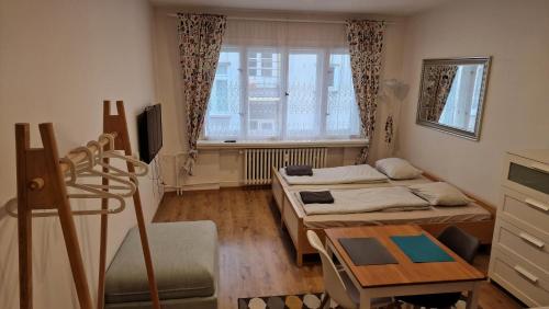 プラハにあるPrague city centreのベッド2台、テーブル、窓が備わる客室です。
