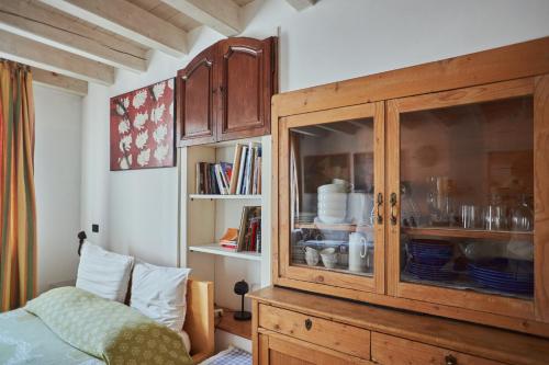 um quarto com um armário de madeira com pratos em Antiche Mura - Bassano Dieda em Bassano del Grappa