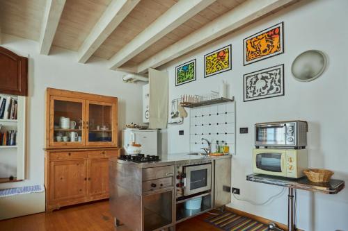 a kitchen with a stove and a microwave at Antiche Mura - Bassano Dieda in Bassano del Grappa