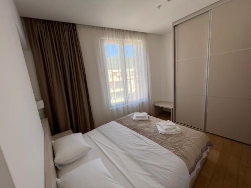 a bedroom with a white bed and a window at Seabreeze apartments Budva in Budva