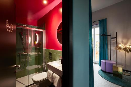 e bagno con servizi igienici, lavandino e pareti rosse. di JO&JOE ROMA a Roma