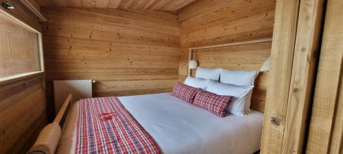 een slaapkamer met een bed in een houten hut bij Chalet La Petite Ourse in Hohrod