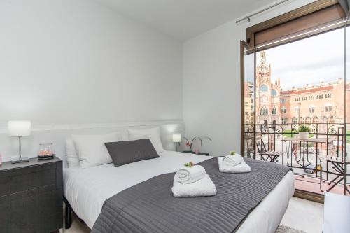 a bedroom with a large bed with towels on it at Lodging Sant Pau Views- Suite with View on Hospital Sant Pau in Barcelona