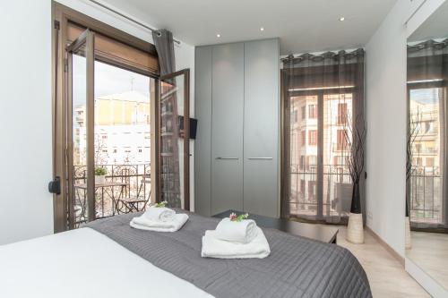 a bedroom with a bed with towels on it at Lodging Sant Pau Views- Suite with View on Hospital Sant Pau in Barcelona