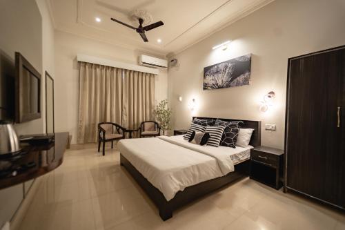 um quarto com uma cama e uma ventoinha de tecto em The Autograph-By Alhanney em Guwahati