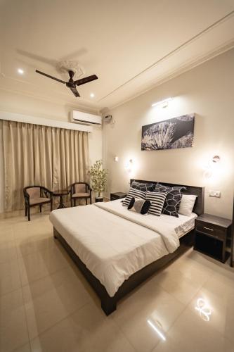 a bedroom with a large bed with a ceiling fan at The Autograph-By Alhanney in Guwahati