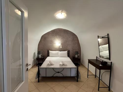 a bedroom with a bed and two tables and a door at Vinas Place City Center in Fira
