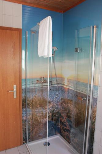 a bathroom with a shower with a painting of the beach at Pension Dorfengel in Berolzheim