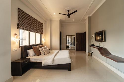 a bedroom with a bed and a ceiling fan at The Autograph-By Alhanney in Guwahati