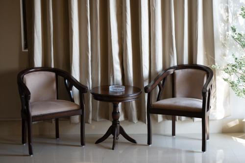 two chairs and a table in front of a window at The Autograph-By Alhanney in Guwahati