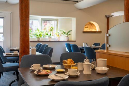 a dining room with chairs and a table with food on it at Hotel Schwanen in Kehl am Rhein