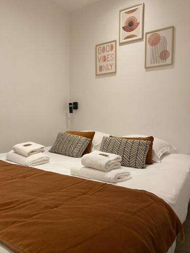 Elle comprend un grand lit avec des draps blancs et des serviettes. dans l'établissement St Germain-Bon Marché - cosy n°2, à Paris