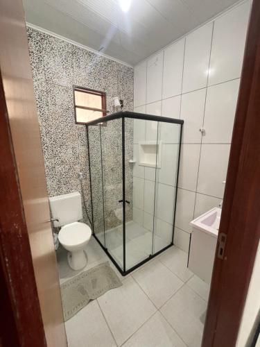 ein Bad mit einer Glasdusche und einem WC in der Unterkunft Casa Toque dos Milagres in São Miguel dos Milagres