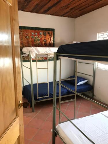 Zimmer mit 2 Etagenbetten und einer Tür in der Unterkunft RiverMan Hostel, Tourism and Friends in Jagua