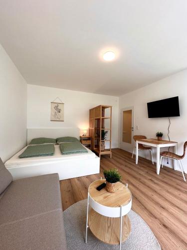 a bedroom with a bed and a couch and a table at StayRoom Apartments I "Woody2" neben Donaulände in Linz