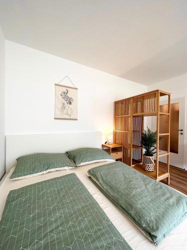 a bedroom with two beds and a book shelf at StayRoom Apartments I "Woody2" neben Donaulände in Linz