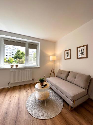 a living room with a couch and a window at StayRoom Apartments I "Woody2" neben Donaulände in Linz