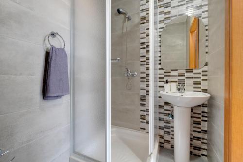 y baño con ducha, lavabo y aseo. en Stunning 2BR Holiday Penthouse in Central Sliema en Sliema