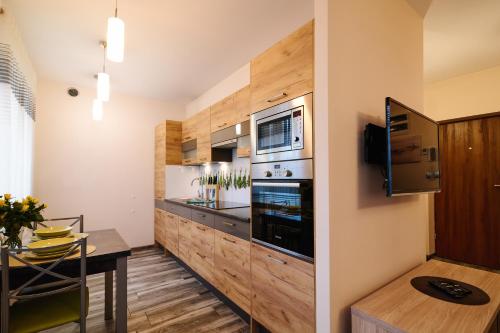 a kitchen with stainless steel appliances and wooden cabinets at Apartament Lukas in Kędzierzyn-Koźle