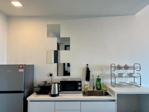 una cocina con fregadero y refrigerador en Welcome Suite at Trefoil Setia Alam, en Shah Alam