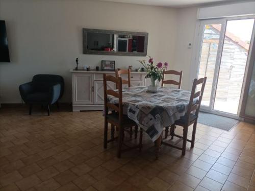 uma sala de jantar com uma mesa com cadeiras e uma mesa; em Maison proche circuit 24 heures du mans em Spay