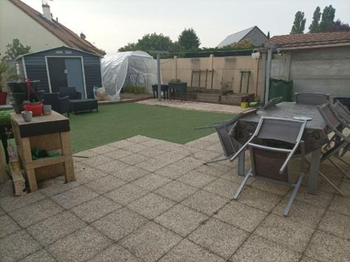 a patio with a grill and a table in a yard at Maison proche circuit 24 heures du mans in Spay